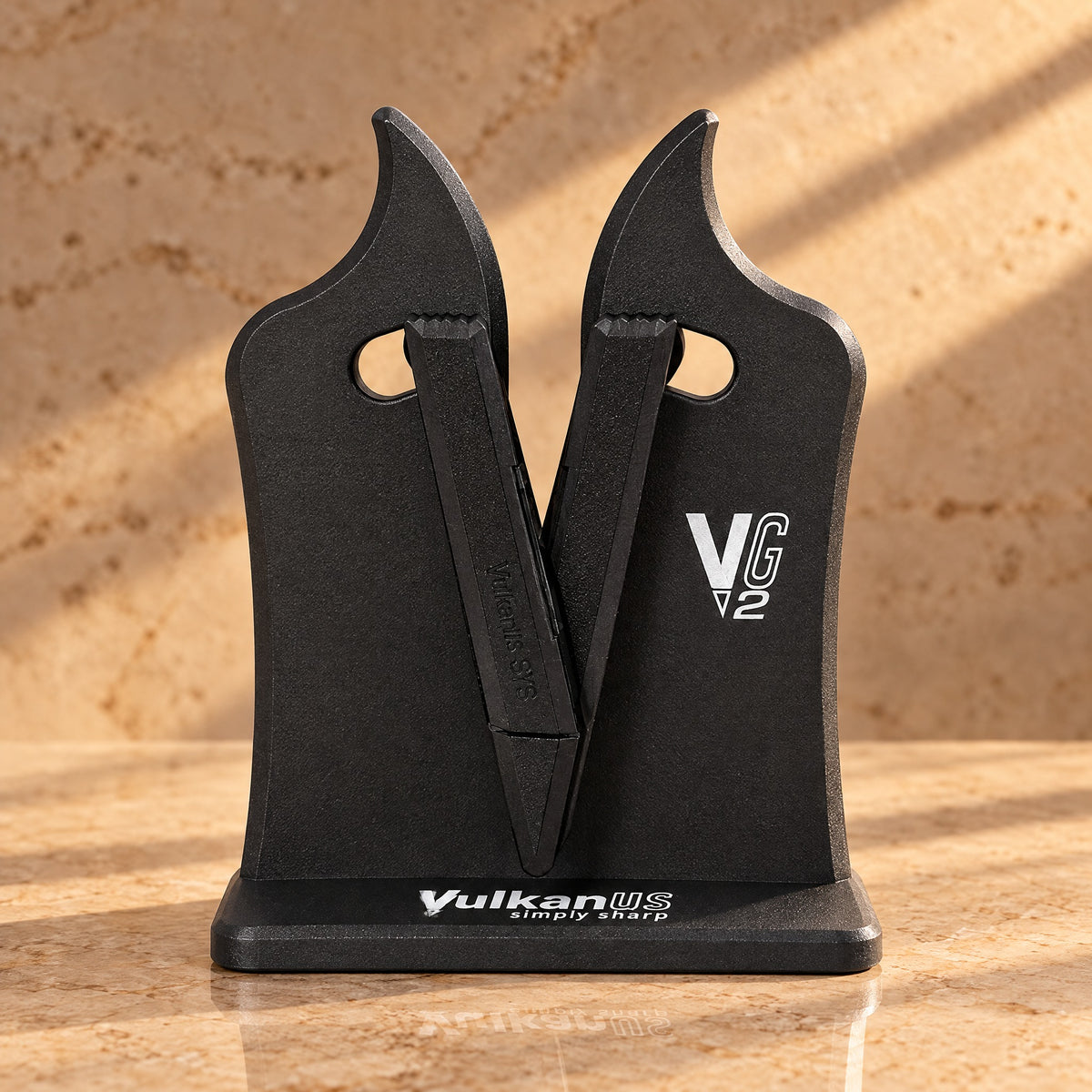 Vulkanus VG2 Classic Messerschärfer in Schwarz auf einer Marmor-Arbeitsplatte im warmen Licht, Frontansicht (KI-Szene)